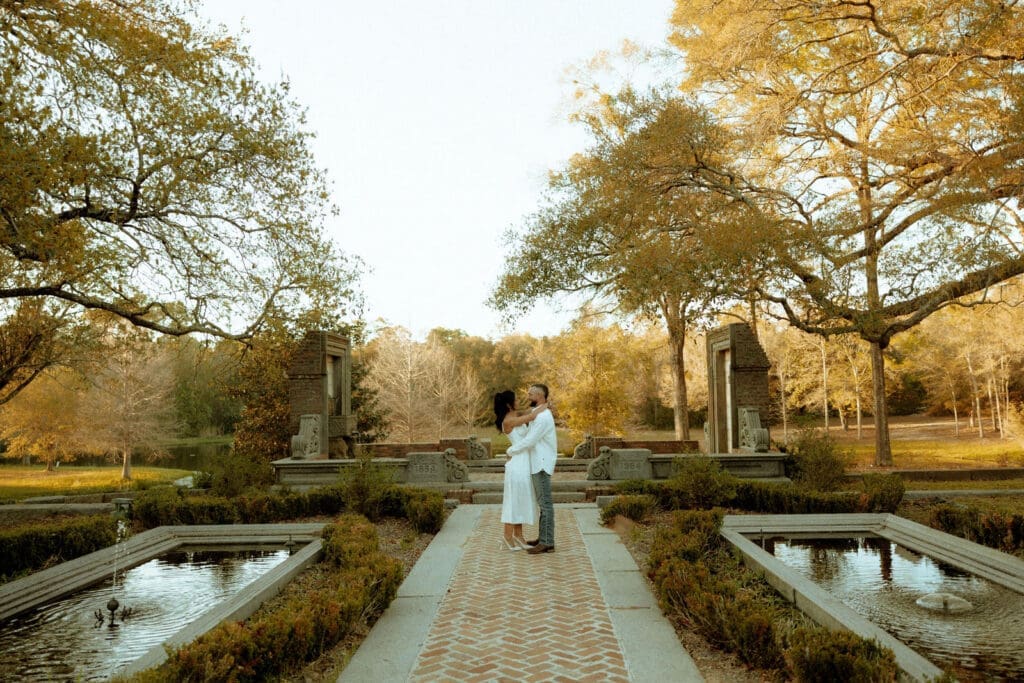 Couple embracing during a romantic outdoor engagement session photographed by Mobile Alabama engagement photographer Highland Film + Photo.