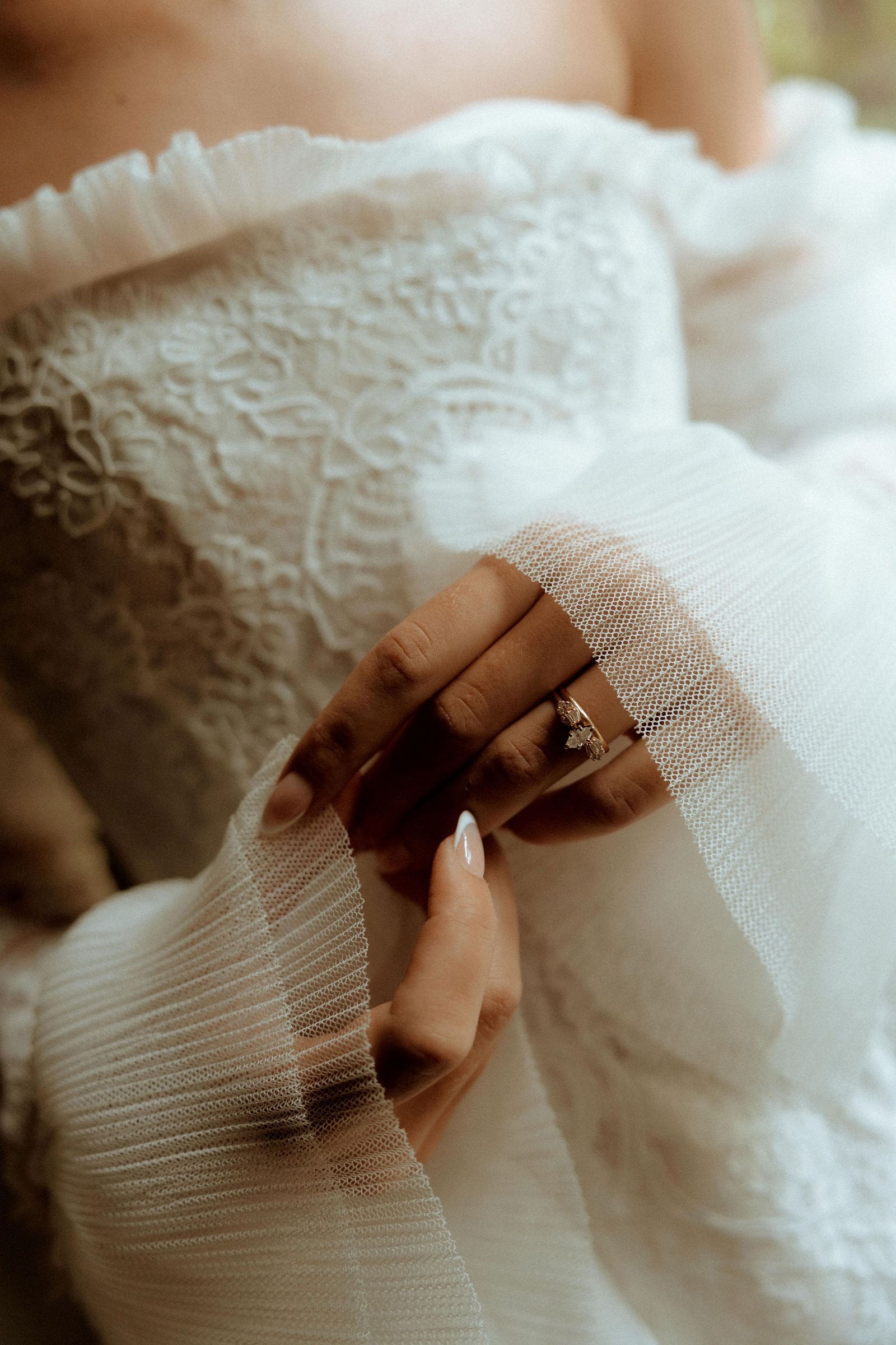 Close-up of a bride’s hands holding her veil, showcasing her engagement ring and lace wedding dress during a wedding in Atlanta, Georgia, photographed in a romantic, film-inspired style.