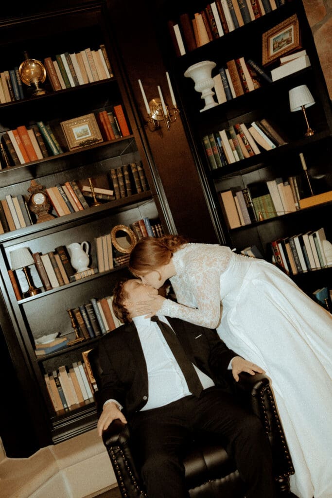 Bride leaning in to kiss her groom inside the historic Stonehaven mansion during their wedding day in Cullman, Alabama.