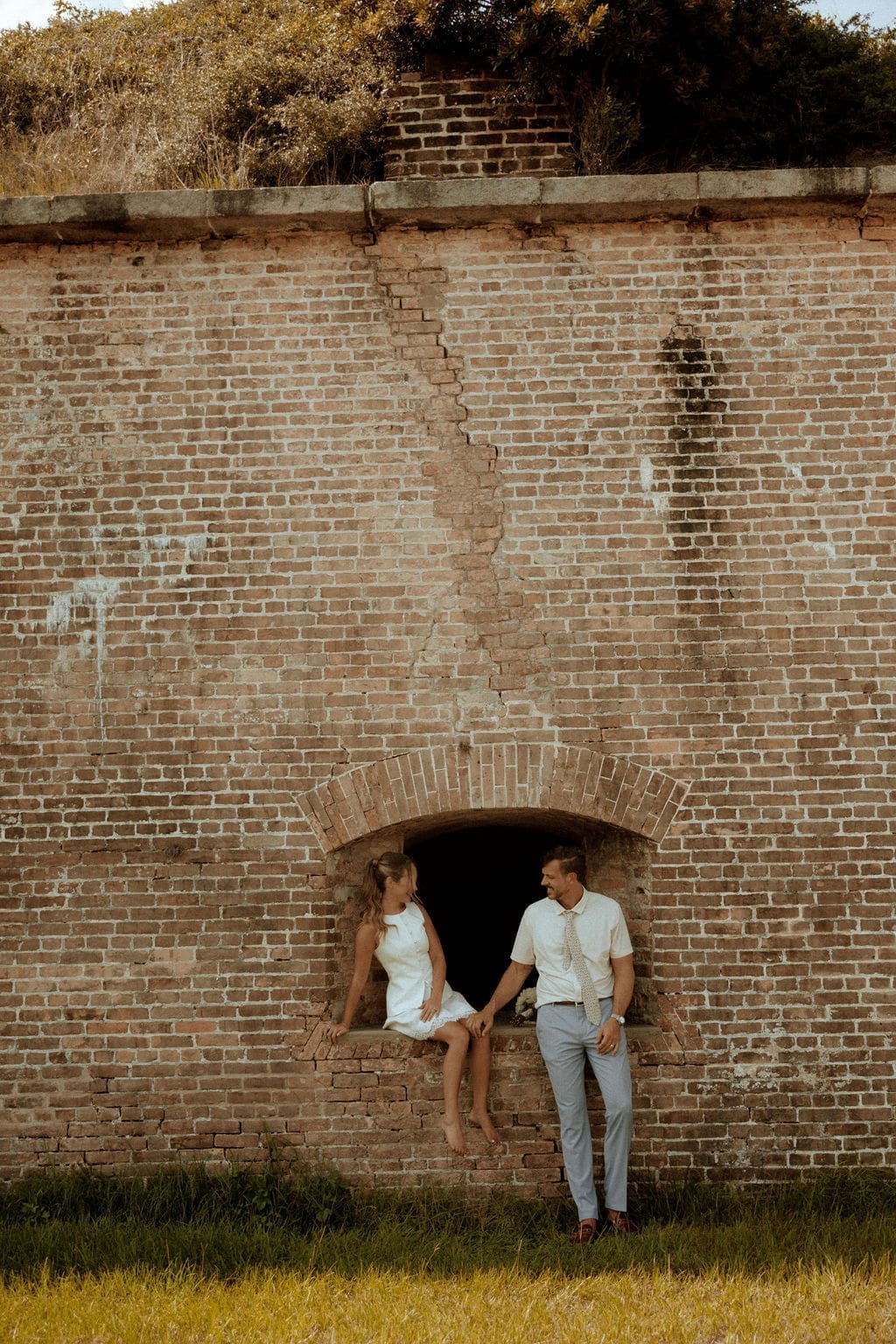 Newly married couple Andi and Travis embrace at Fort Pickens in Pensacola, Florida after their intimate courthouse elopement, photographed on digital and film.
