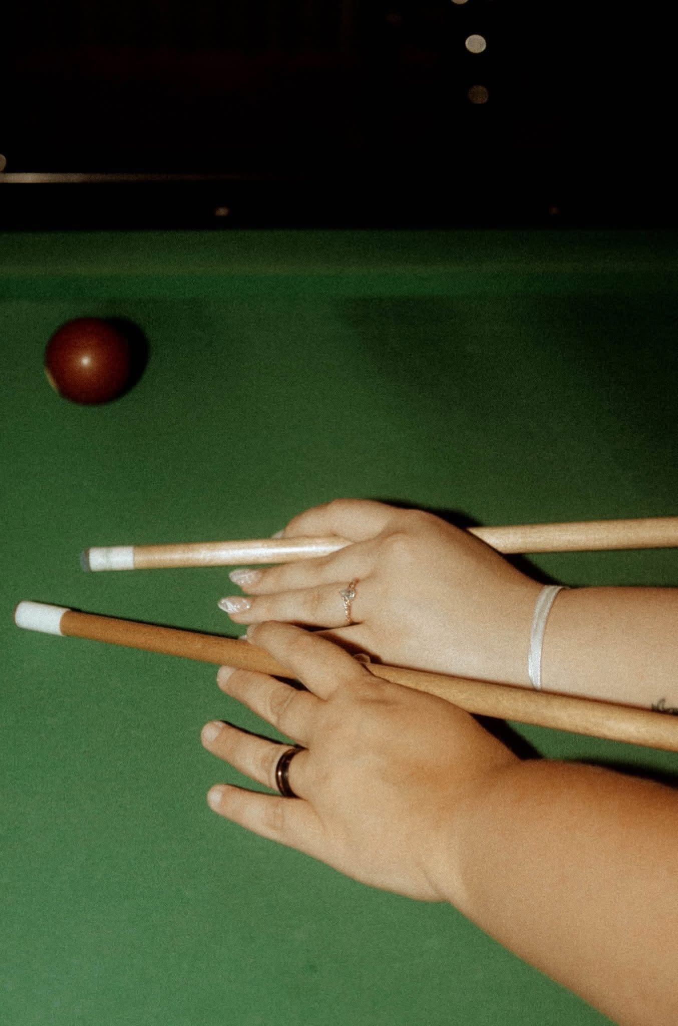 Couple playing pool during a creative engagement session in Mobile, Alabama.