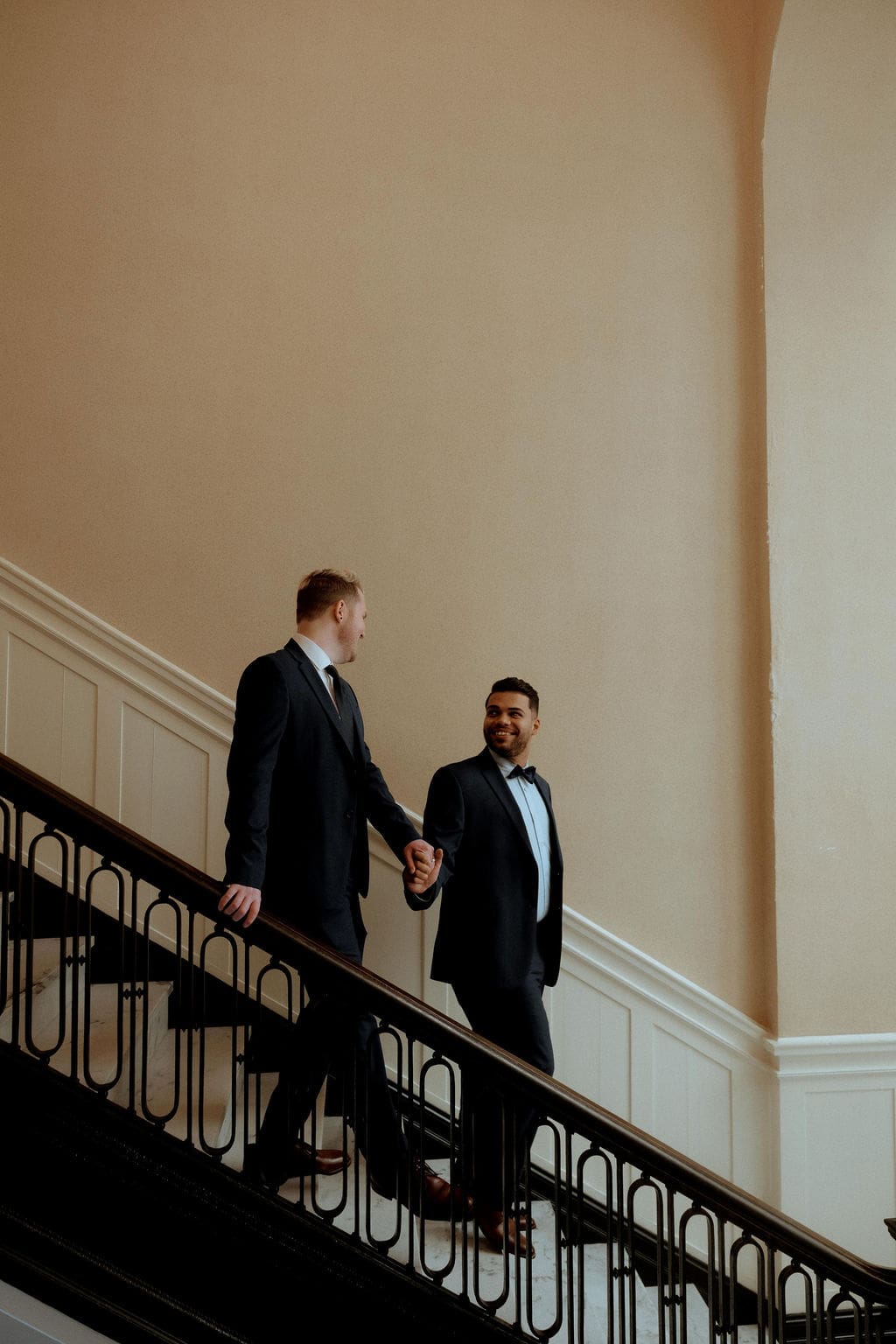 Hunter and Trae walking down the stairs during their romantic engagement session at the History Museum of Mobile in downtown Mobile, Alabama.