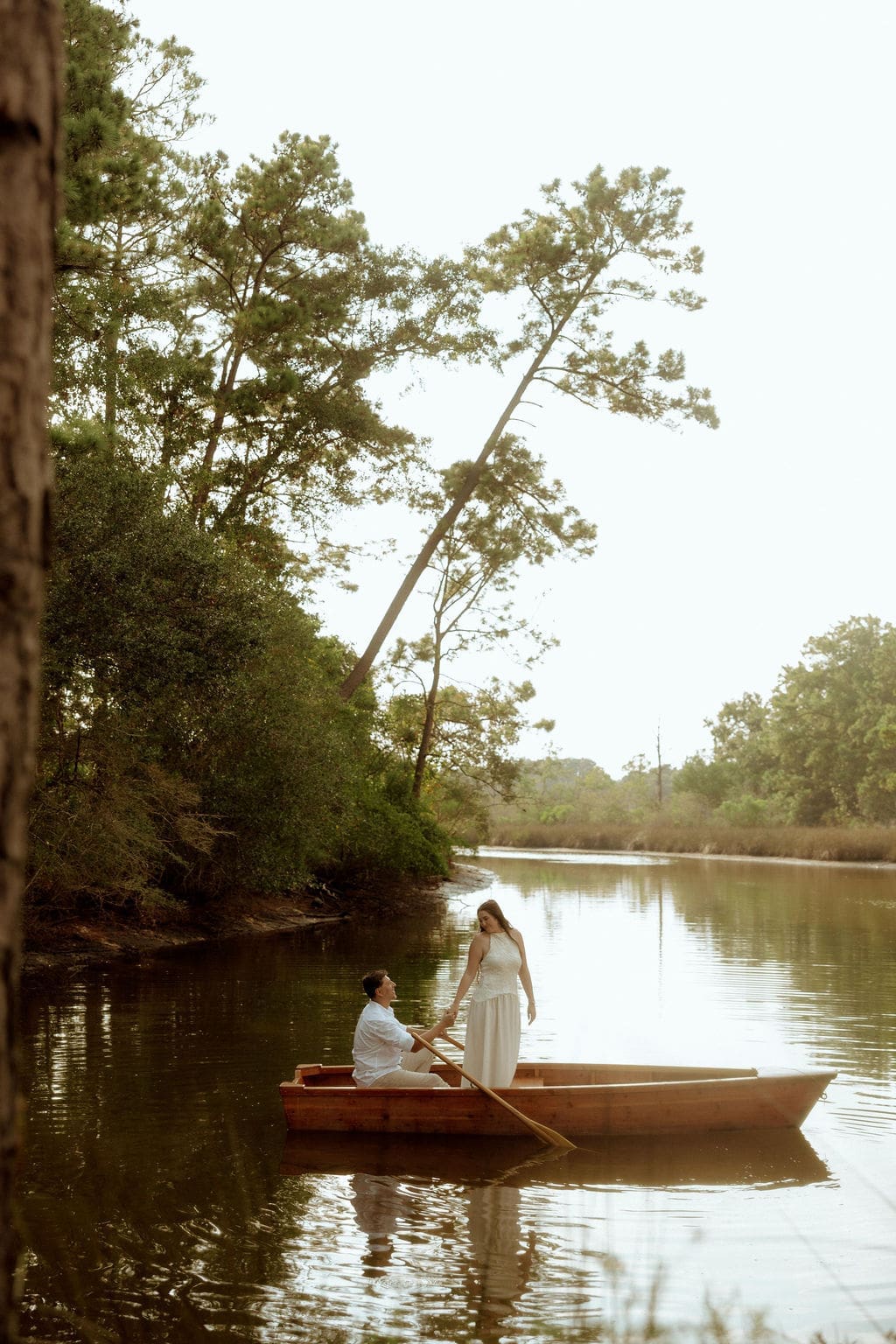 Couple sitting together in a canoe on a peaceful river during a romantic, The Notebook-inspired engagement session photographed by Highland Film + Photo.